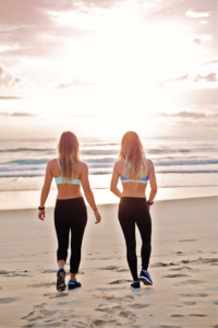 two girls on the beach in activewear