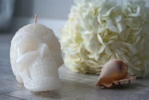 Skeleton candle by seashell and flowers