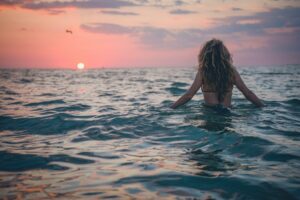 girl in water with the sunset 